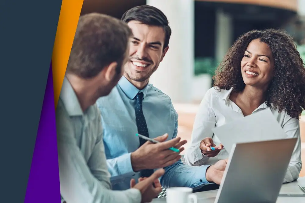 Team discussing strategies around a laptop.